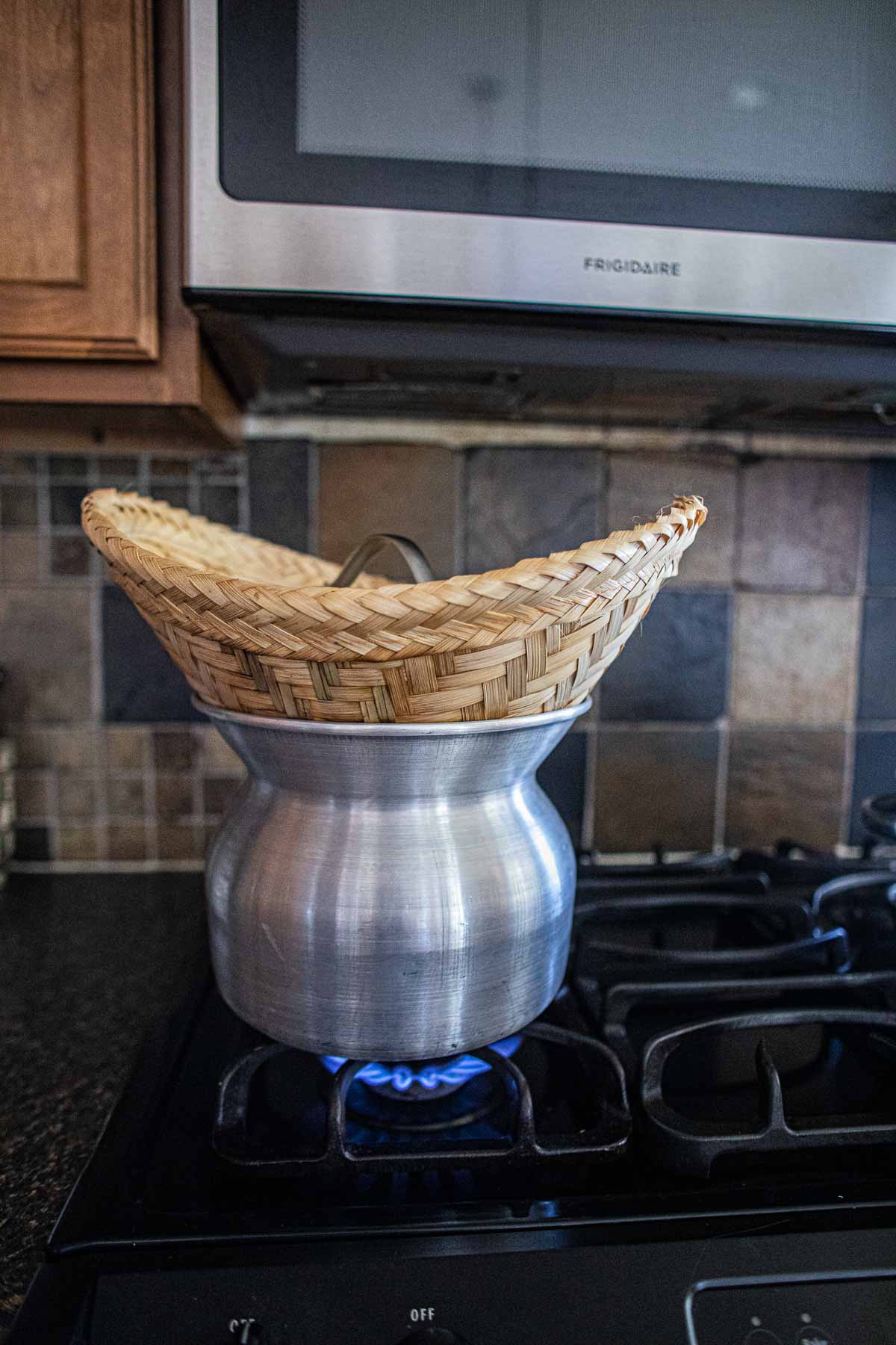 Thai sticky rice in a bamboo steamer on the stove.