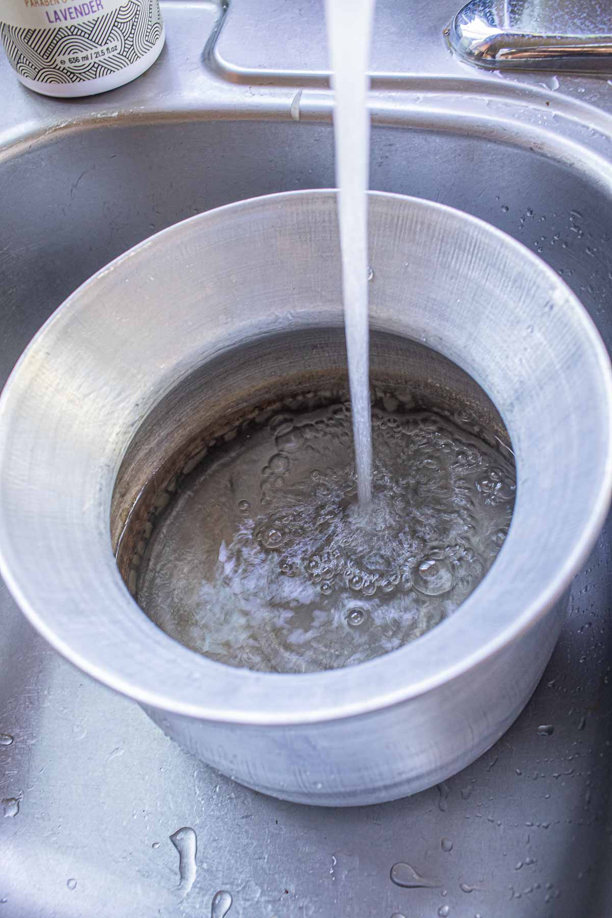 Filling sticky rice conical cone with running water. 