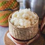 Thai sticky rice in a bamboo basket over the table.