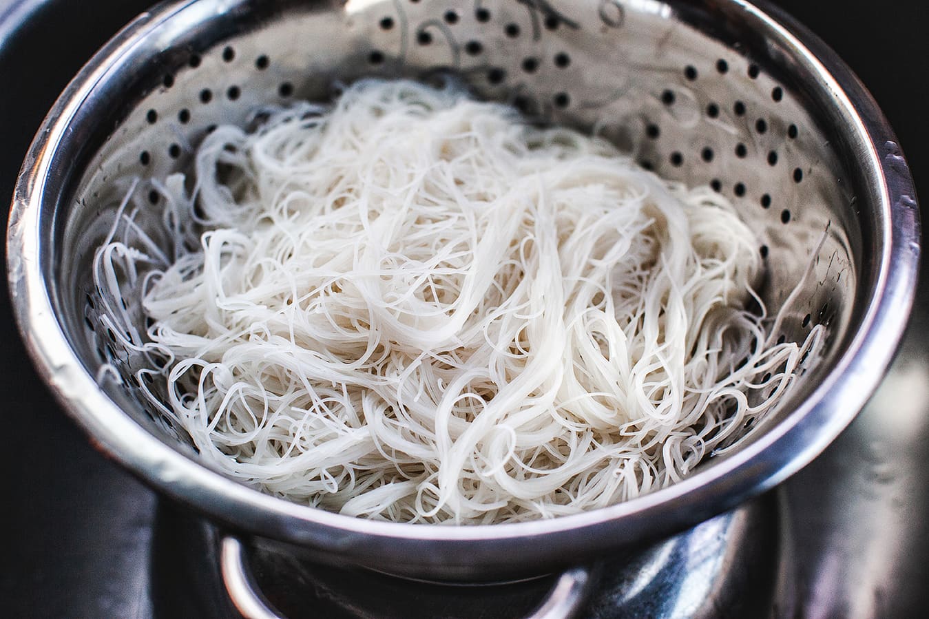 Rice noodles in a colander