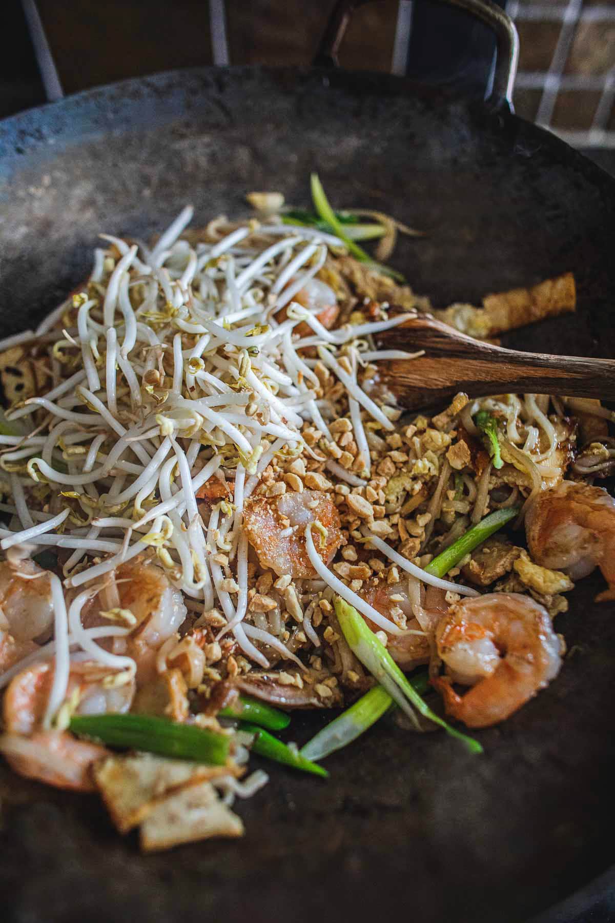 pad thai stir fry in a wok with bean sprouts.