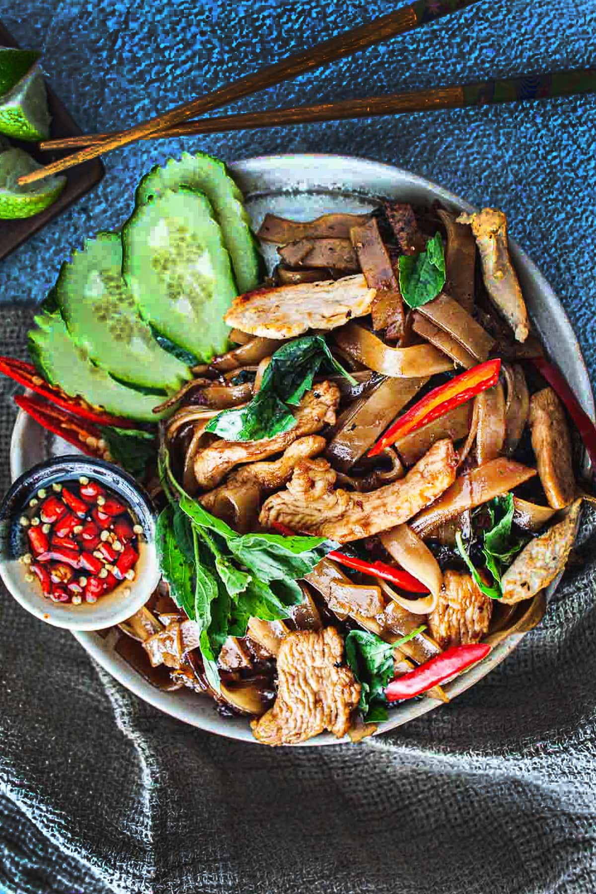 Thai Chicken drunken noodles in a plate on the table with chopsticks. 