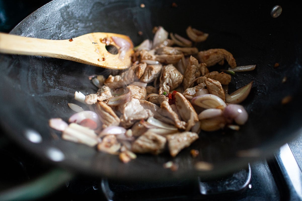 chicken, shallot, garlic and chili frying in a wok for making Pad Kee Mao.