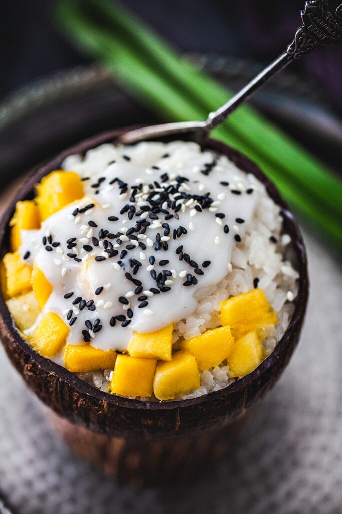 Thai mango sticky rice in a coconut bowl.