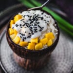 Mango sticky rice in a coconut bowl.