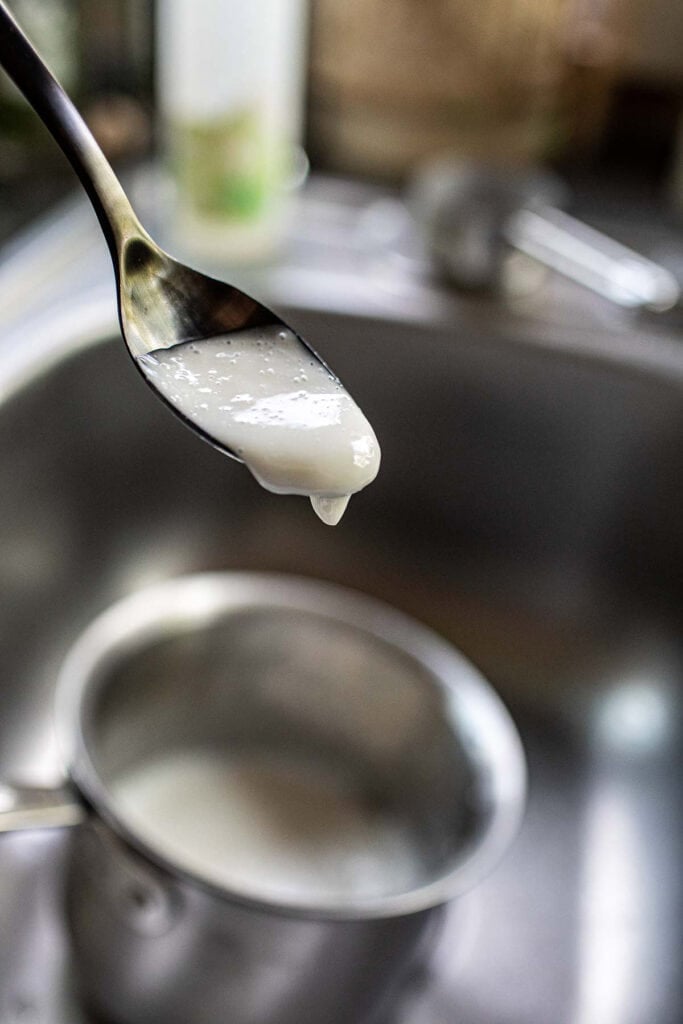 Coconut sauce for mango sticky rice in a spoon.