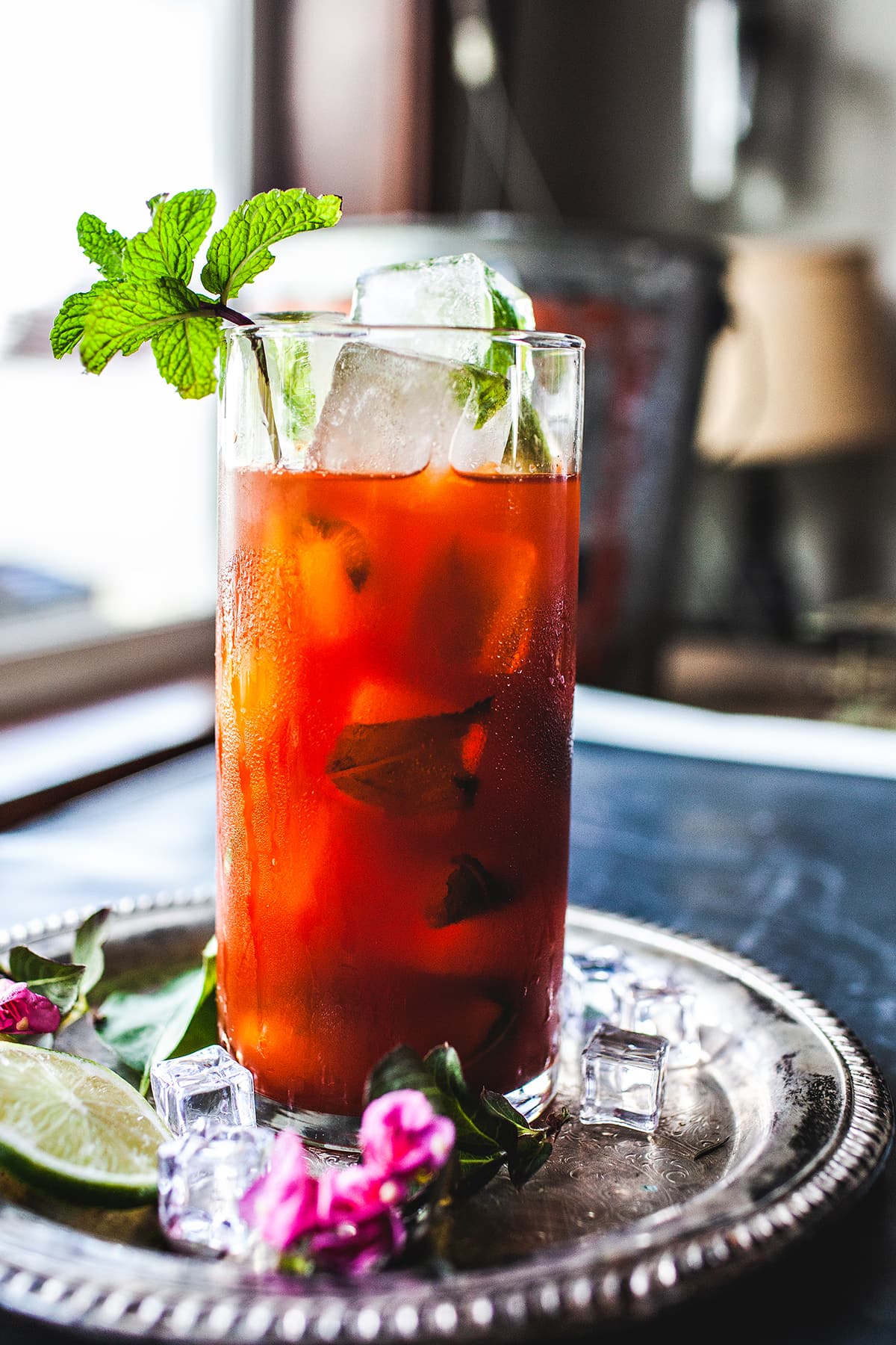 Thai tea drink on a tray with mint garnishes. 
