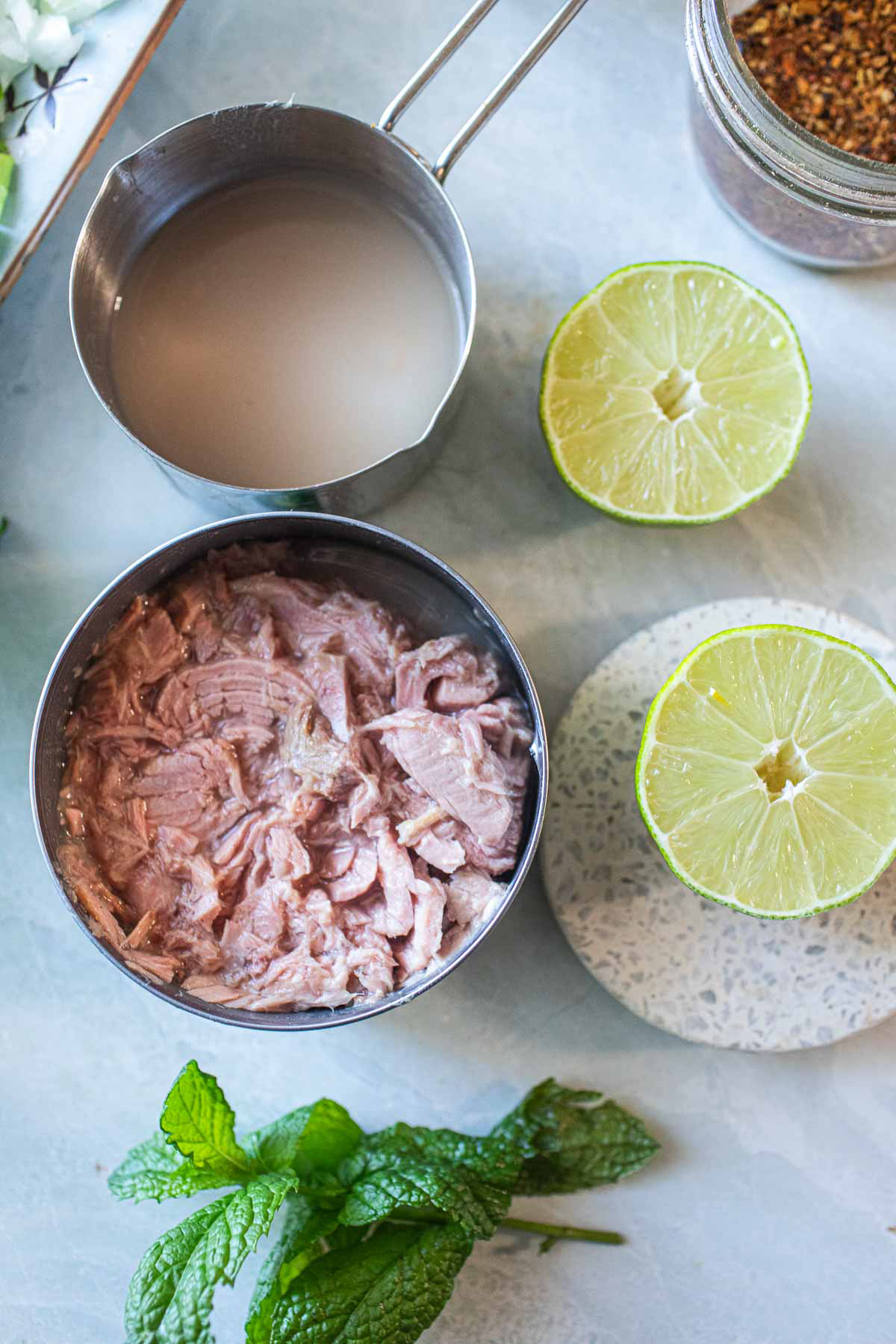 Canned tuna on the table with lime slices.