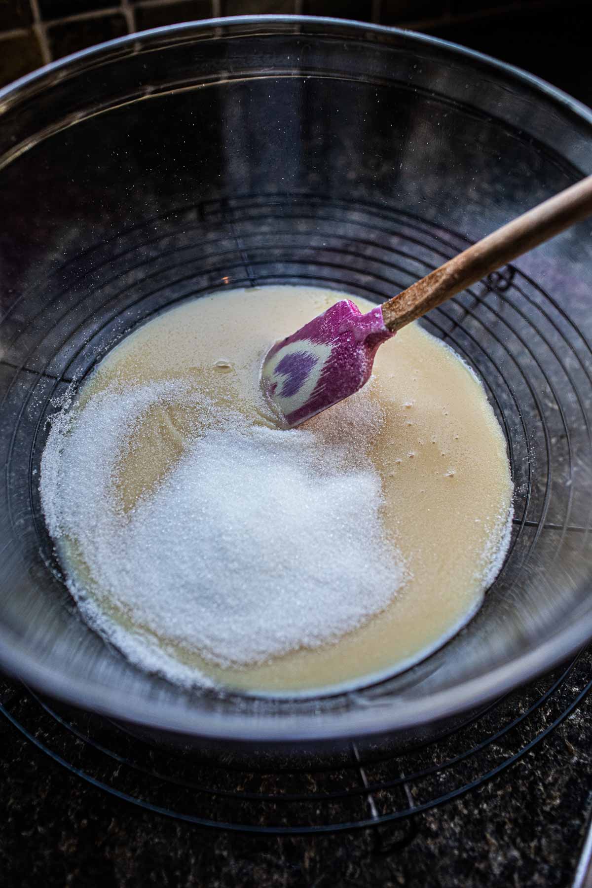 Condensed milk and sugar mixed in a bowl. 