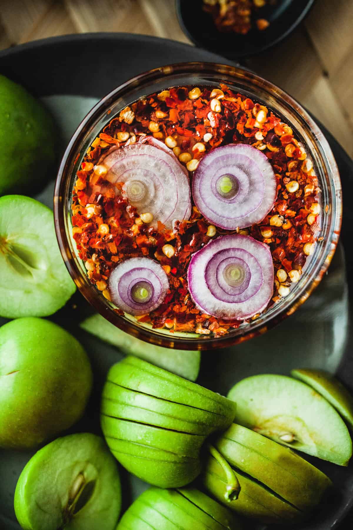 Chili dipping sauce in glass bowl with apples. 