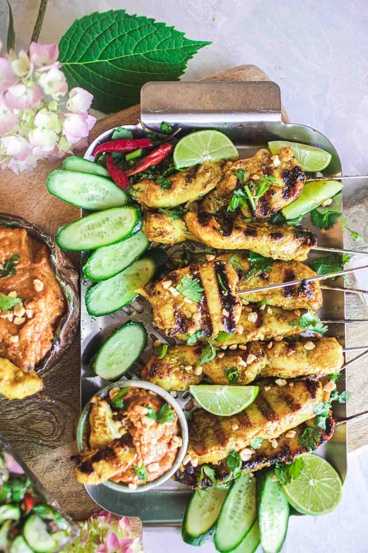 chicken skewers on a plate with vegetables