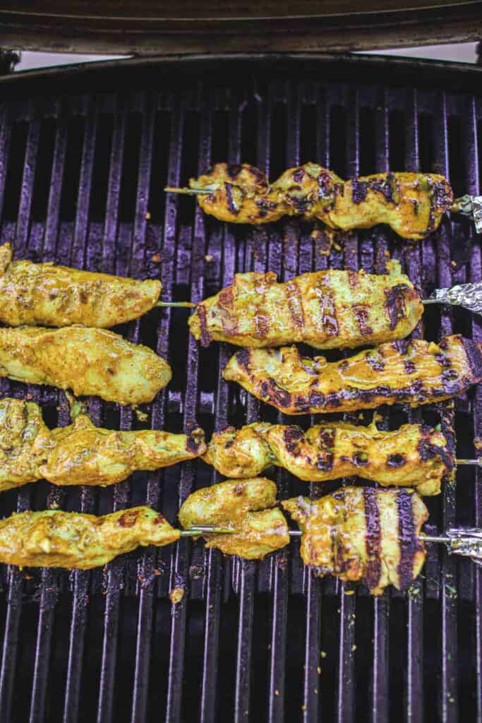 Grilled Thai chicken skewers pieces on the grill.