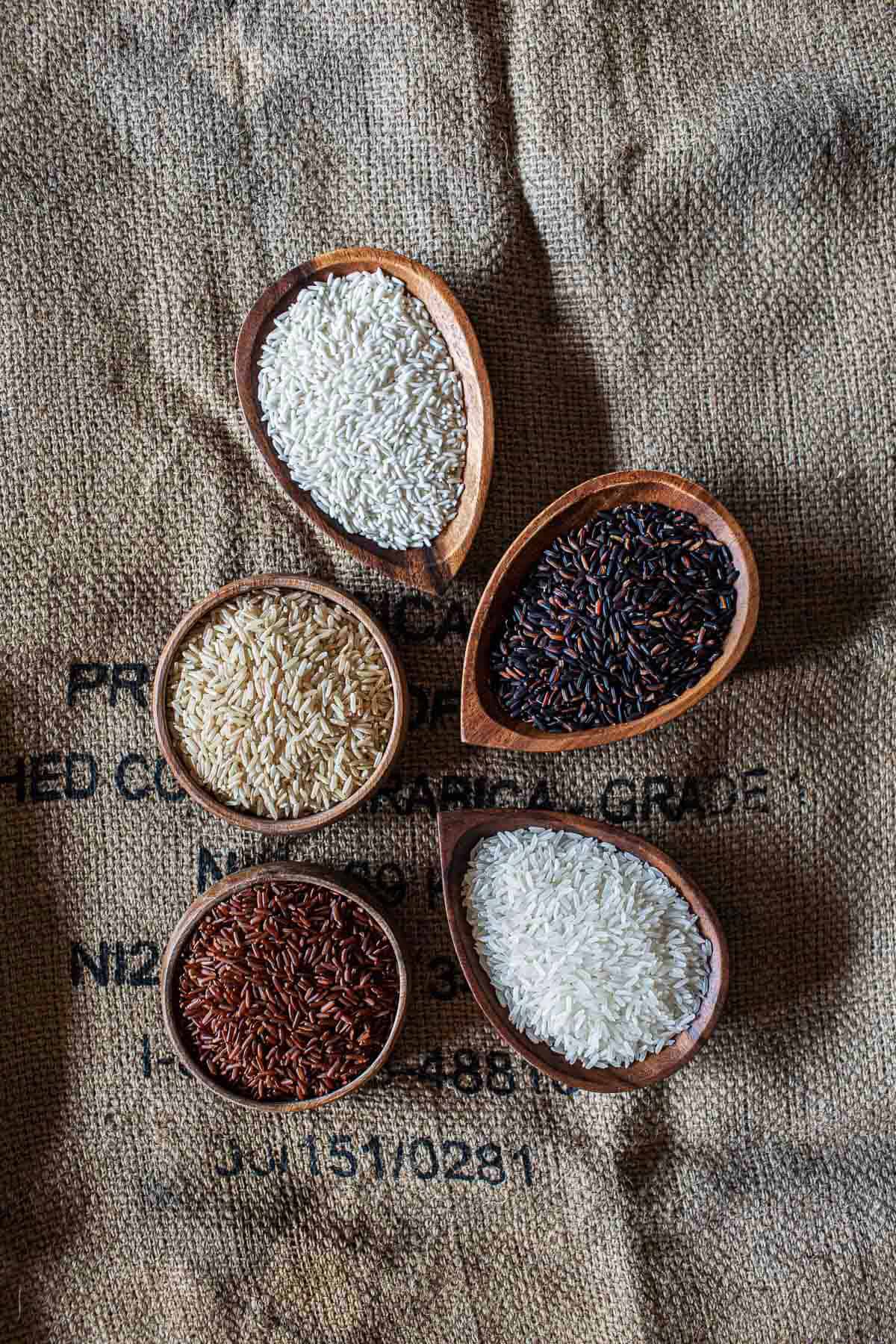 Different types of thai rice in wooden bowls. 