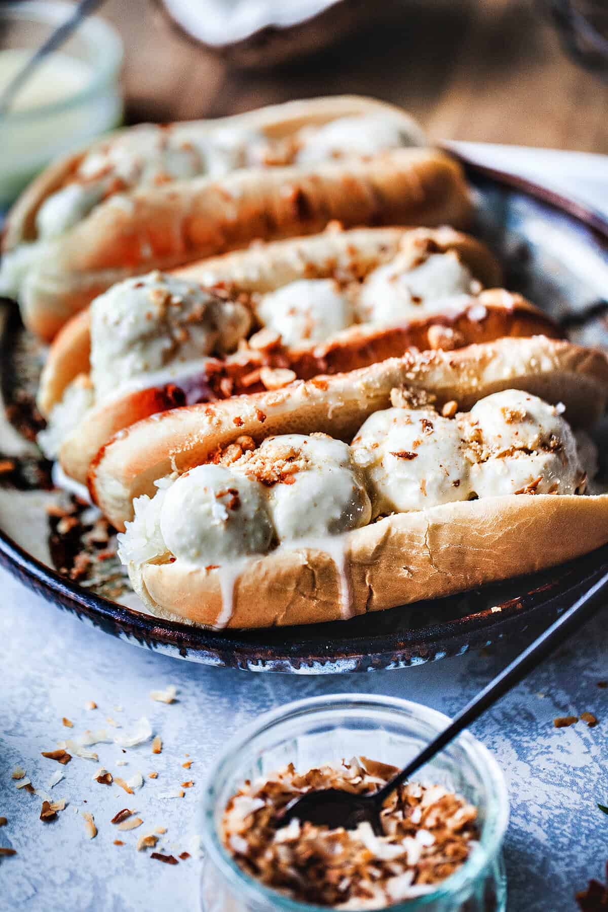 Thai coconut ice cream in hot dog buns on a plate. 