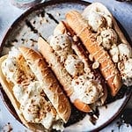 Thai coconut ice cream with hot dog buns on a table.