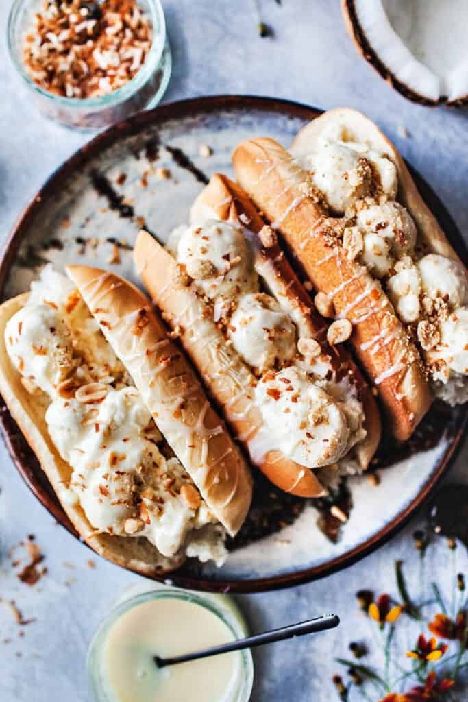 Thai coconut ice cream with hot dog buns on a table.