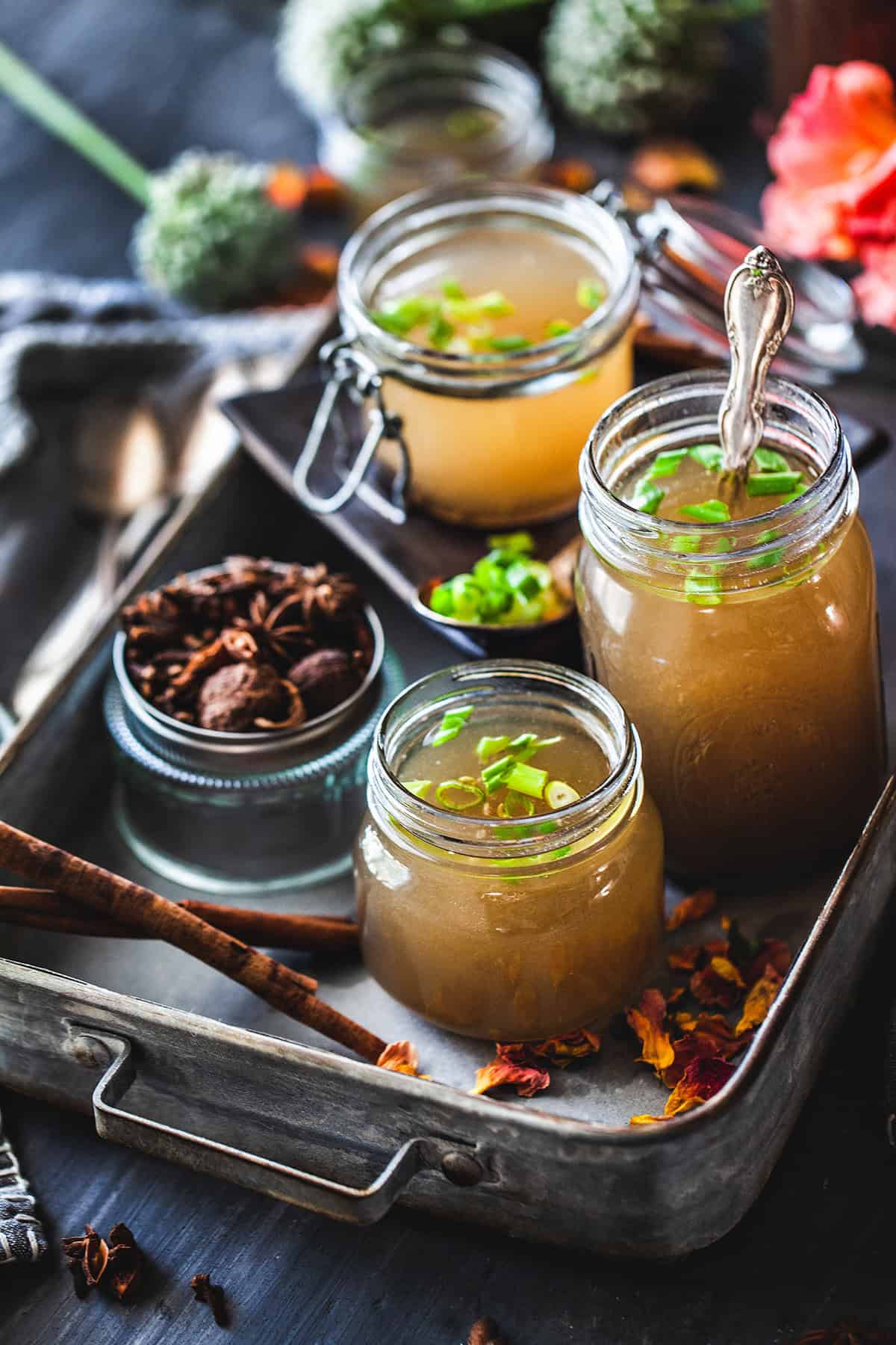 beef bone broth in mason jars on a tray.