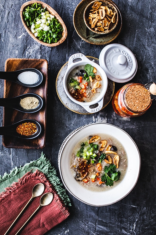 Thai Chicken Rice Soup with condiments, cilantro, green onion, fried garlic, ground chili peppers