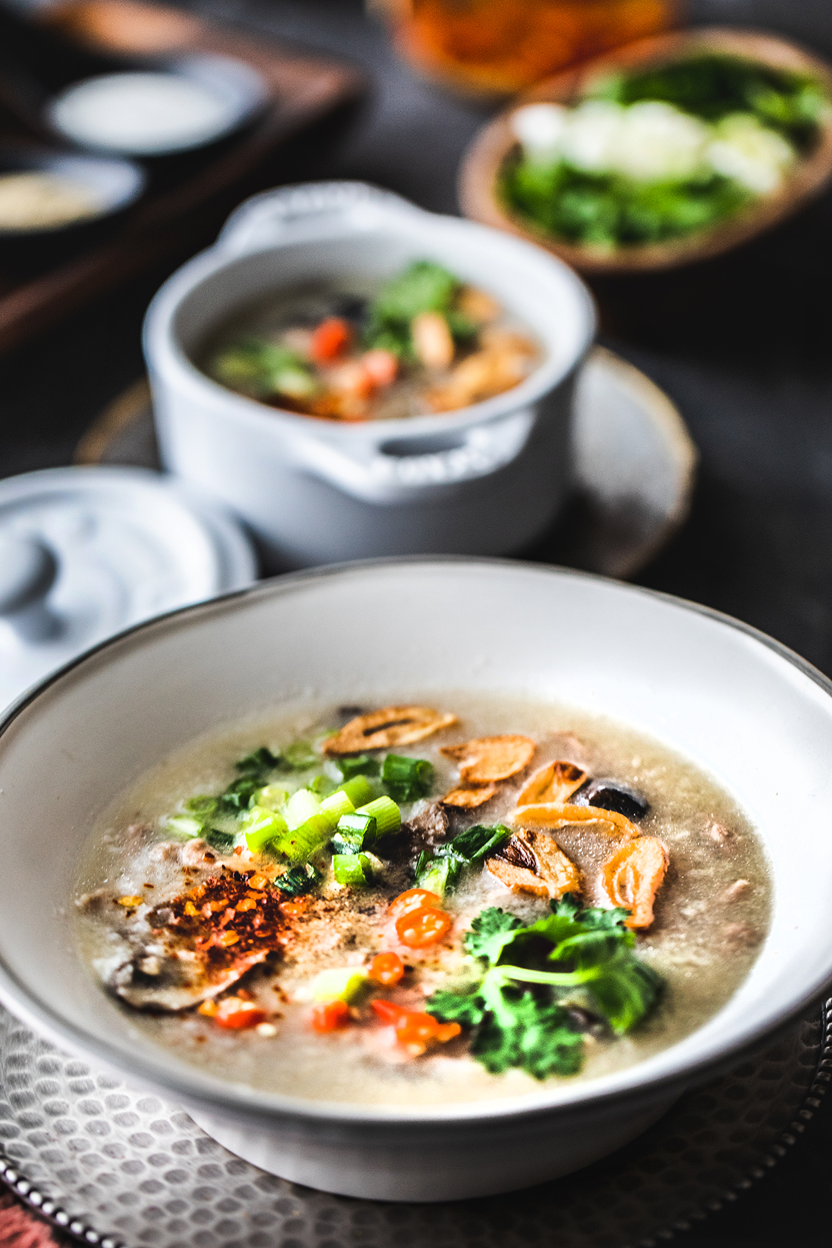 Khao Tom Gai Thai rice soup in a bowl with garnishes.