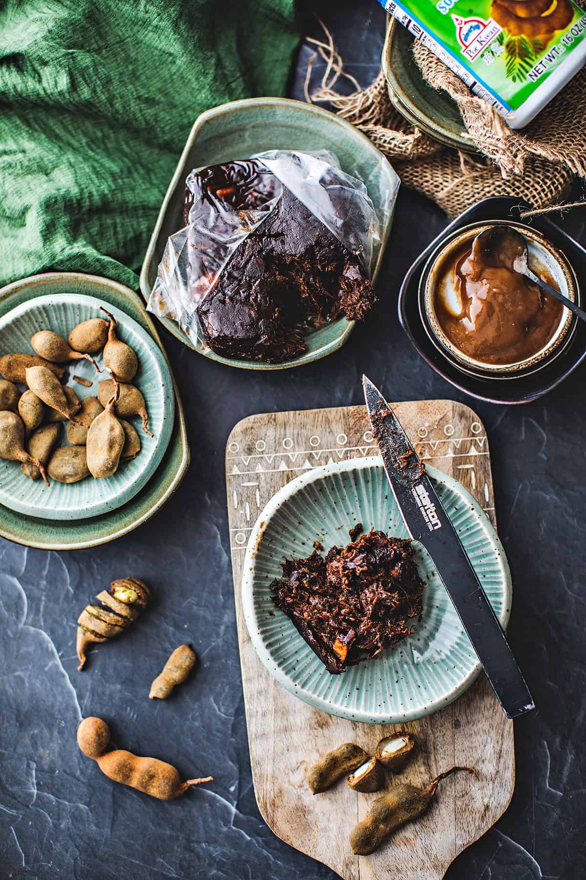 Tamarind paste, sauce and pods on a table. 