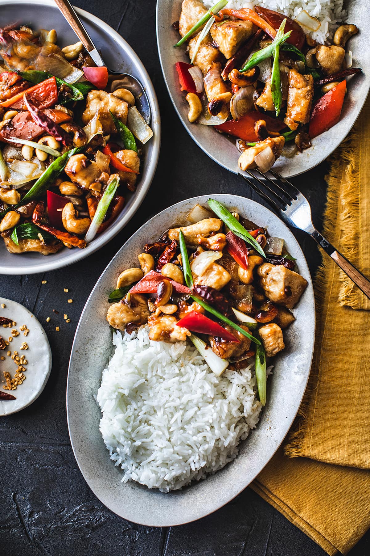 Cashew chicken on 3 platters on the table. 