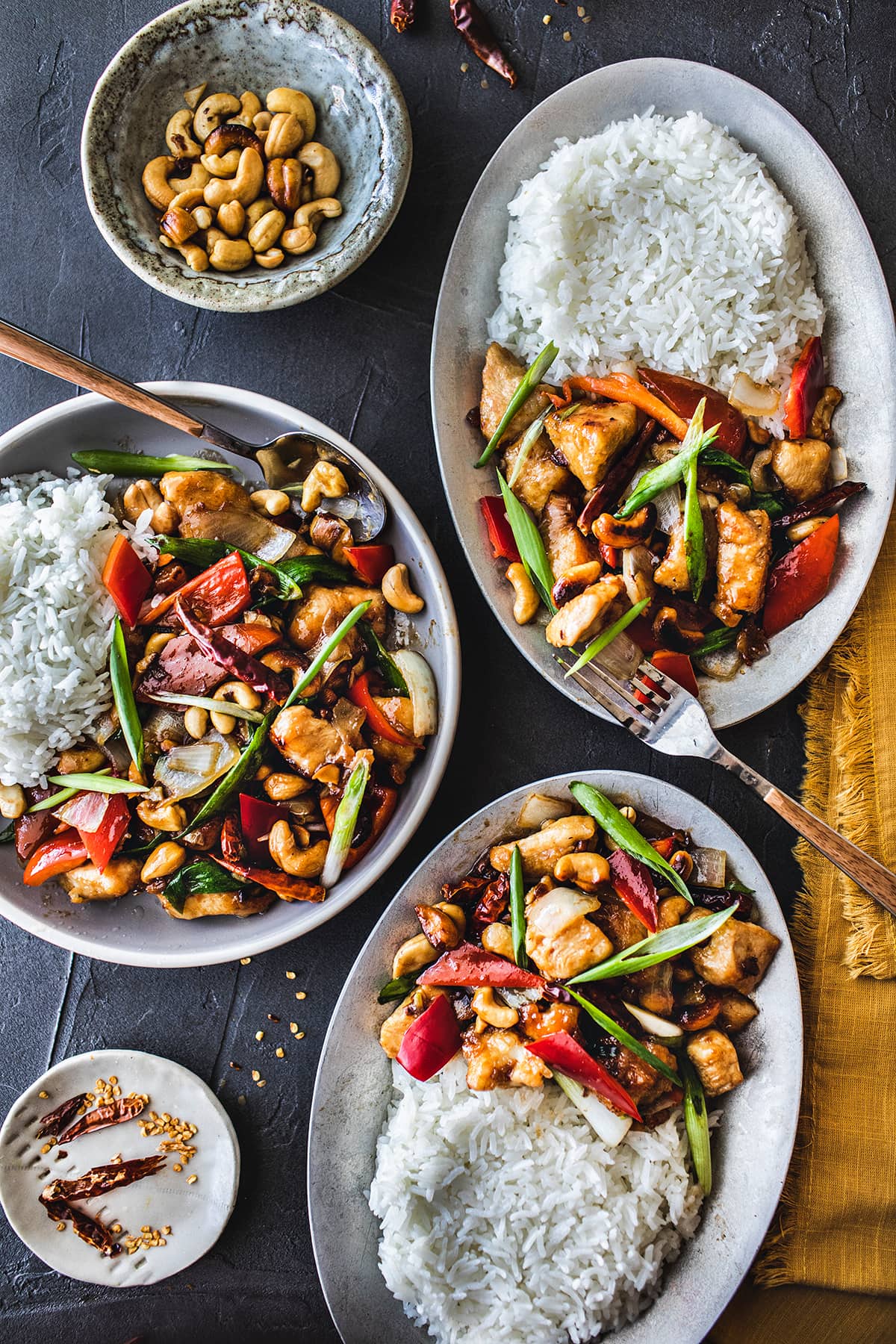 Thai cashew chicken on 3 platters on the table. 