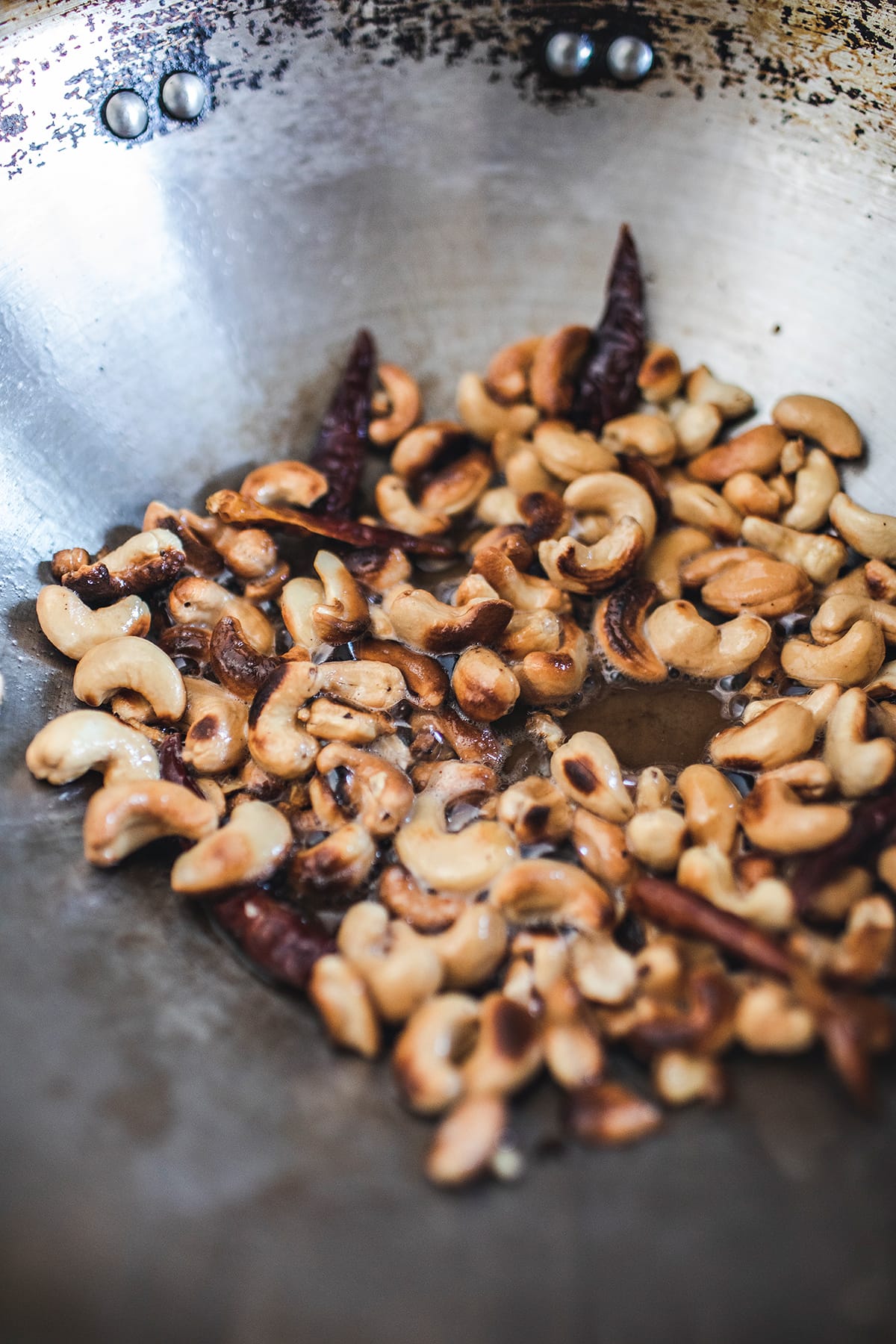 Cashew and dried chilis frying in a wok