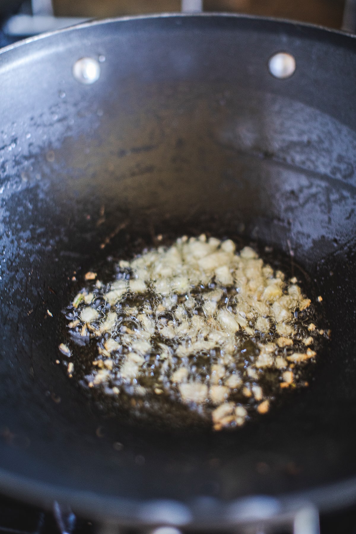 garlic frying in oil in a wok.