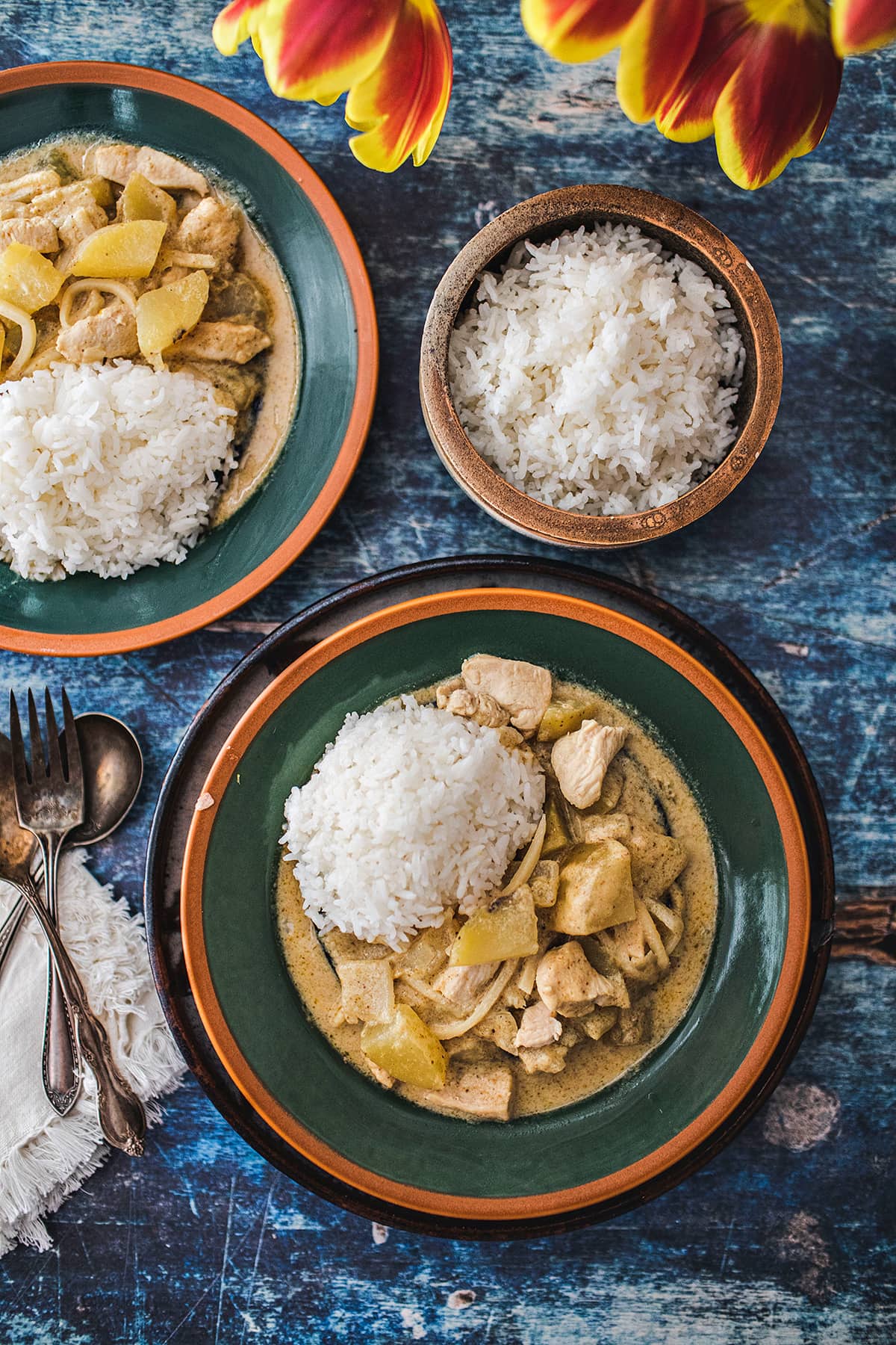 thai yellow curry with chicken on 2 plates with jasmine rice