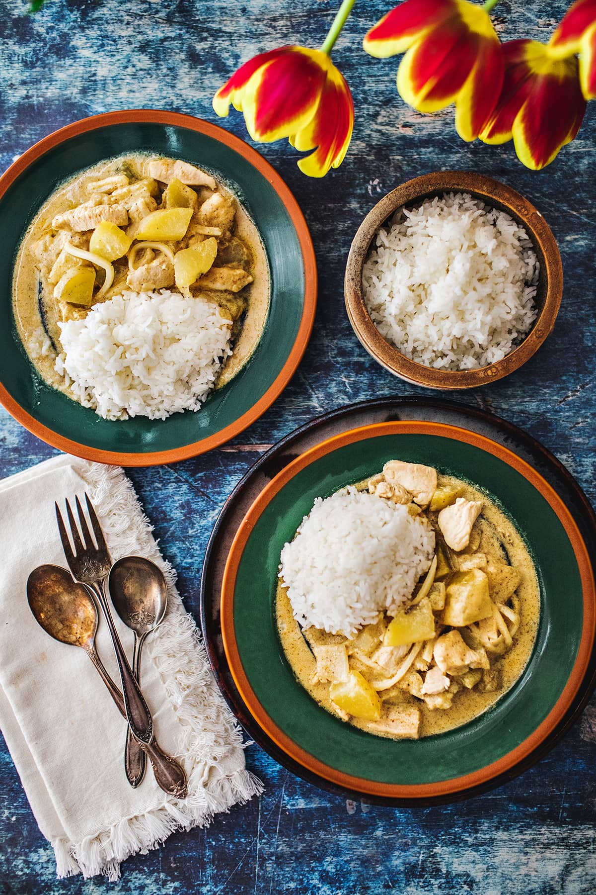 2 plates of yellow curry with side on the side 