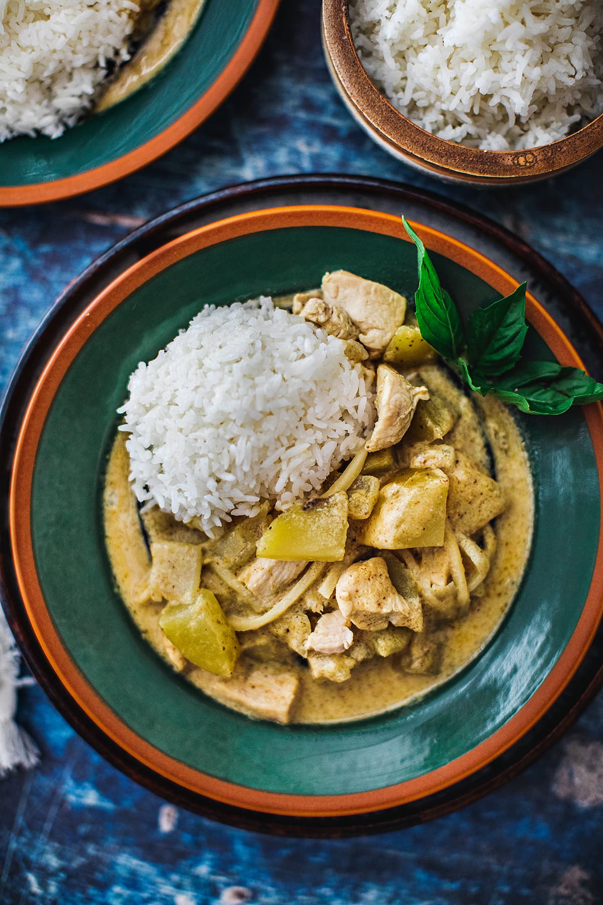 Thai yellow curry one a plate with rice on the side