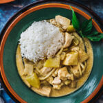 thai chicken yellow curry on a plate with a side of jasmine rice