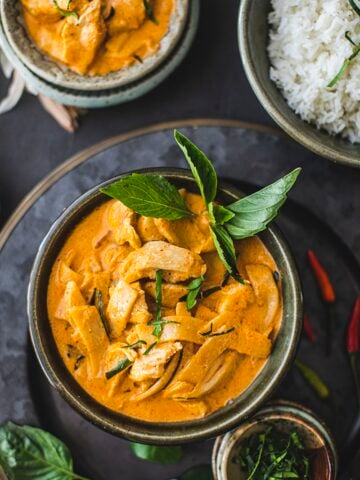 Red curry with basil leaves in a small bowl