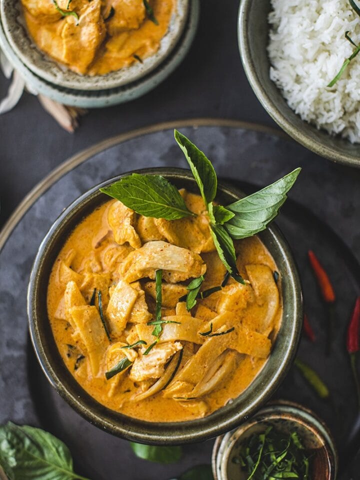 Red curry with basil leaves in a small bowl