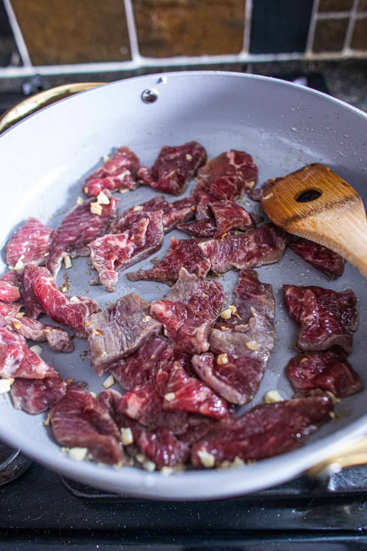 beef stir fried with garlic in pan.