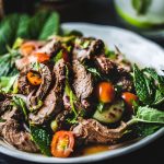 A simple recipe for Thai beef salad made with fresh summer vegetables, herbs, lime juice, and fish sauce. Once you gather all your ingredients for this Thai beef salad recipe, you’ll be eating a tasty meal in less than 30 minutes (minus the marinating part)!  #thaibeefsalad #easybeefsaladrecipe #thaisaladrecipe #spicysaladrecipe