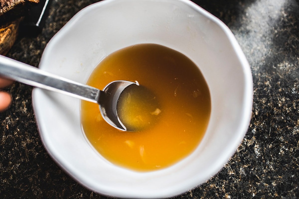 Thai beef salad dressing in a white bowl.