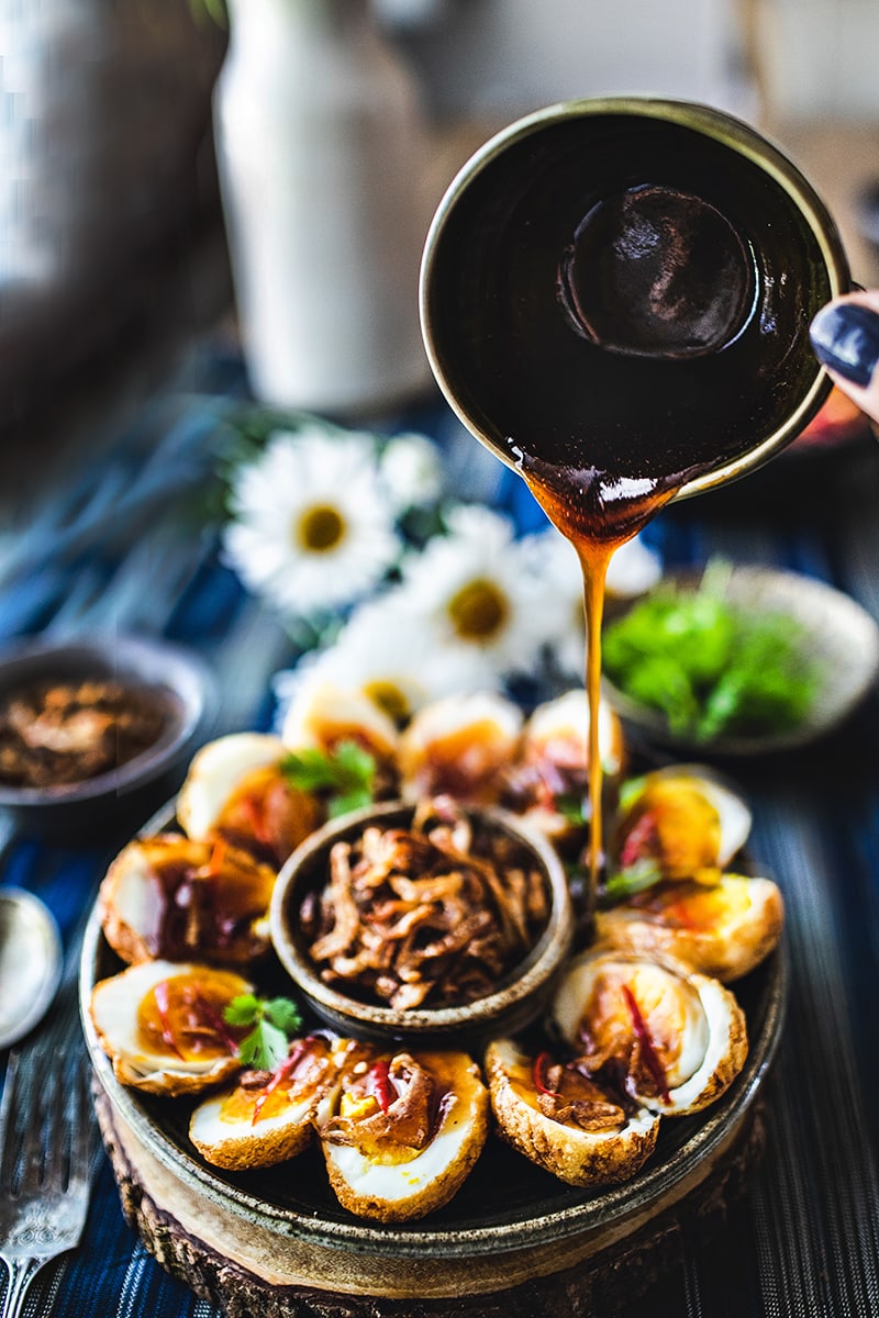 Thai Son-in-Law Eggs is a simple recipe that uses hard-boiled eggs, deep-fried until the skin is golden brown, then served with a perfectly balanced dressing made from tamarind juice, fish sauce, and palm sugar. #soninlaweggs #easythairecipe #padthaisauce