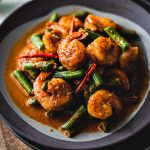 This easy red curry green beans with shrimp, or Pad Prik King, is a simple and delicious Thai dish that lightly fries red curry paste together with coconut cream, shrimp, kaffir lime leaves, and green beans. #redcurry #shrimpcurry #thaifood #thairedcurrry