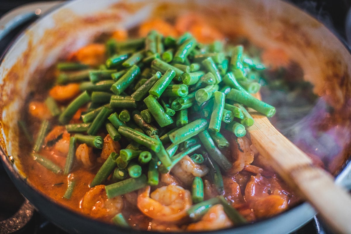 Prik king curry paste and green beans cooking in a pan.