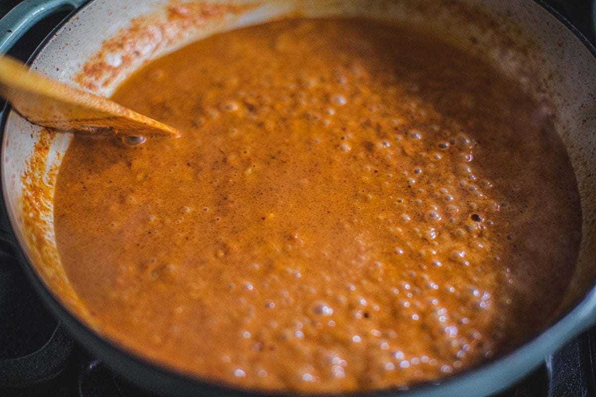 Prik king curry paste and coconut milk in a pan.