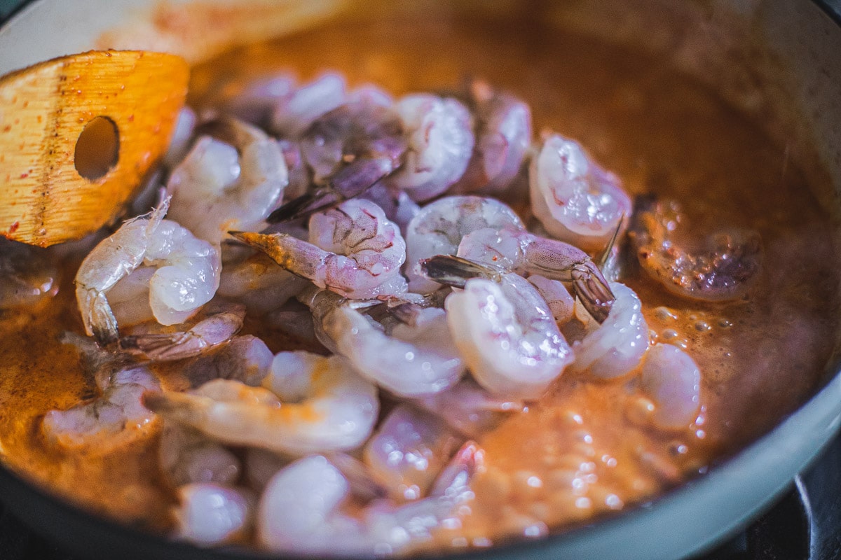 Prik king curry paste and shrimp cooking in a pan.