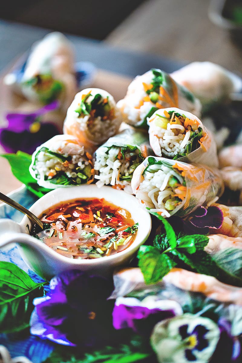 Vietnamese spring rolls on a platter with a dipping sauce.