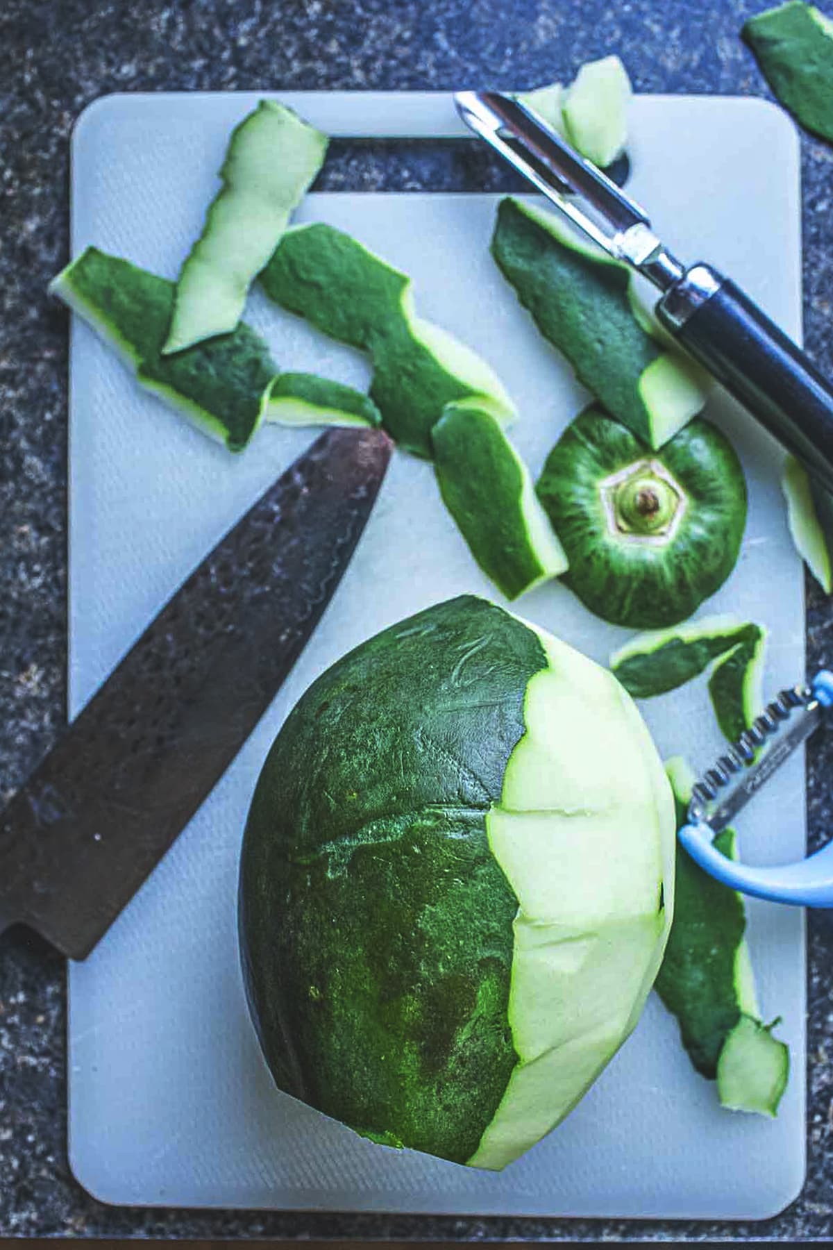 Thai green papaya skin peeled on a cutting board. 