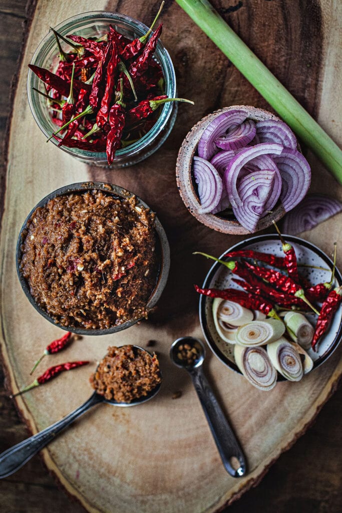 Thai red curry paste in bowls on a cutting board.