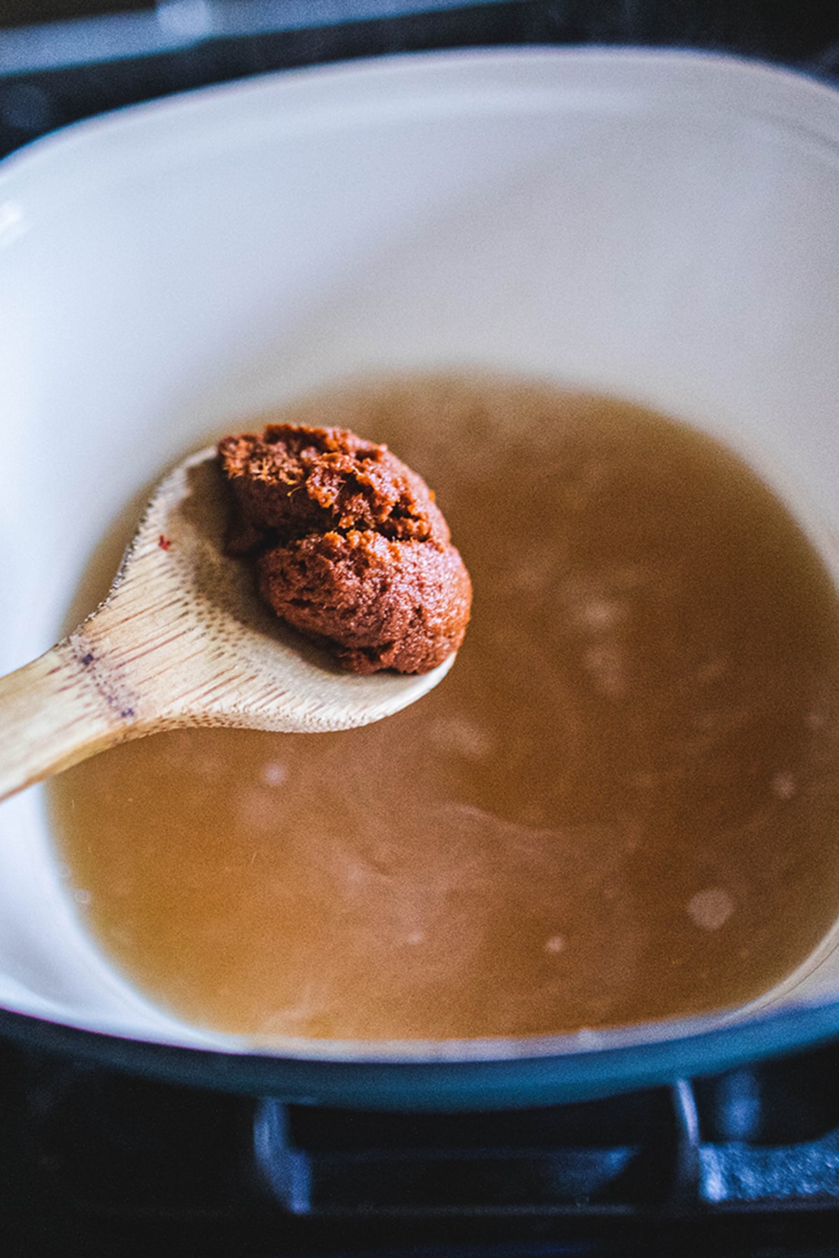 tom yum paste in a wooden spoon to add to broth 