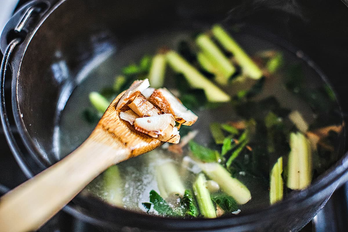 Galangal in a woonden spoon over a pot. 