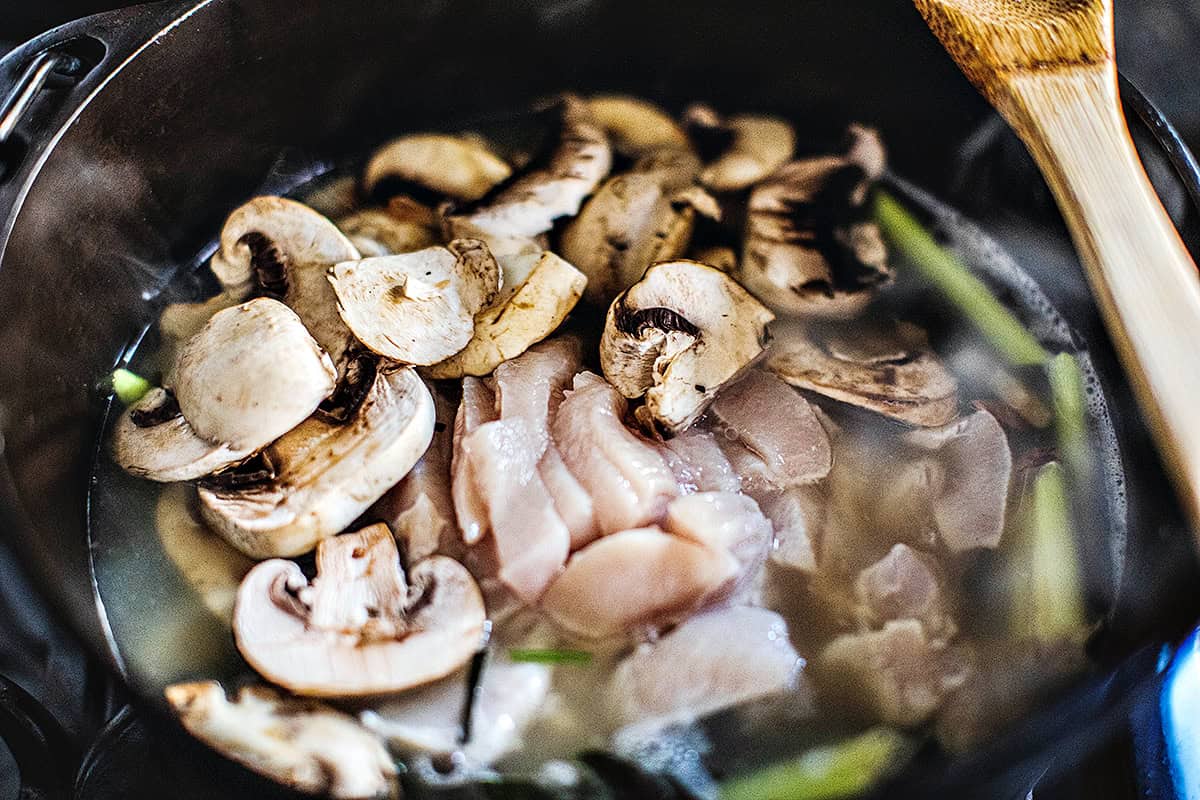 Chicken and mushroom in a pot for Tom Kha soup.