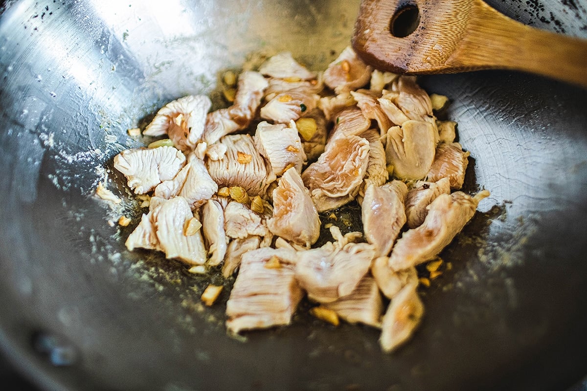 Chicken for pad see ew recipe in a wok.