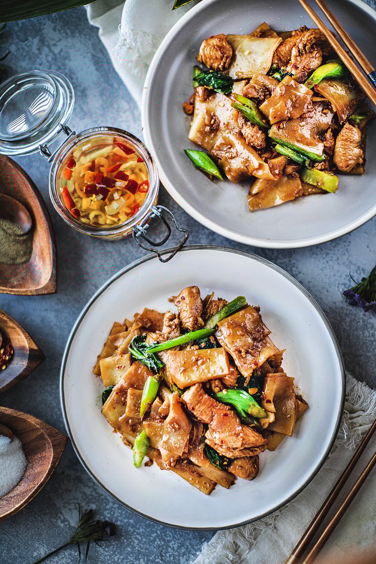 Pad See Ew Pad See Ew with chicken on 2 plates on the table.
